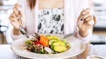 A woman eats a salad.