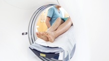 legs sticking out of white MRI machine with nurse in blue scrubs next to patient