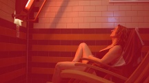 woman sitting in deck chair in sauna with red tint